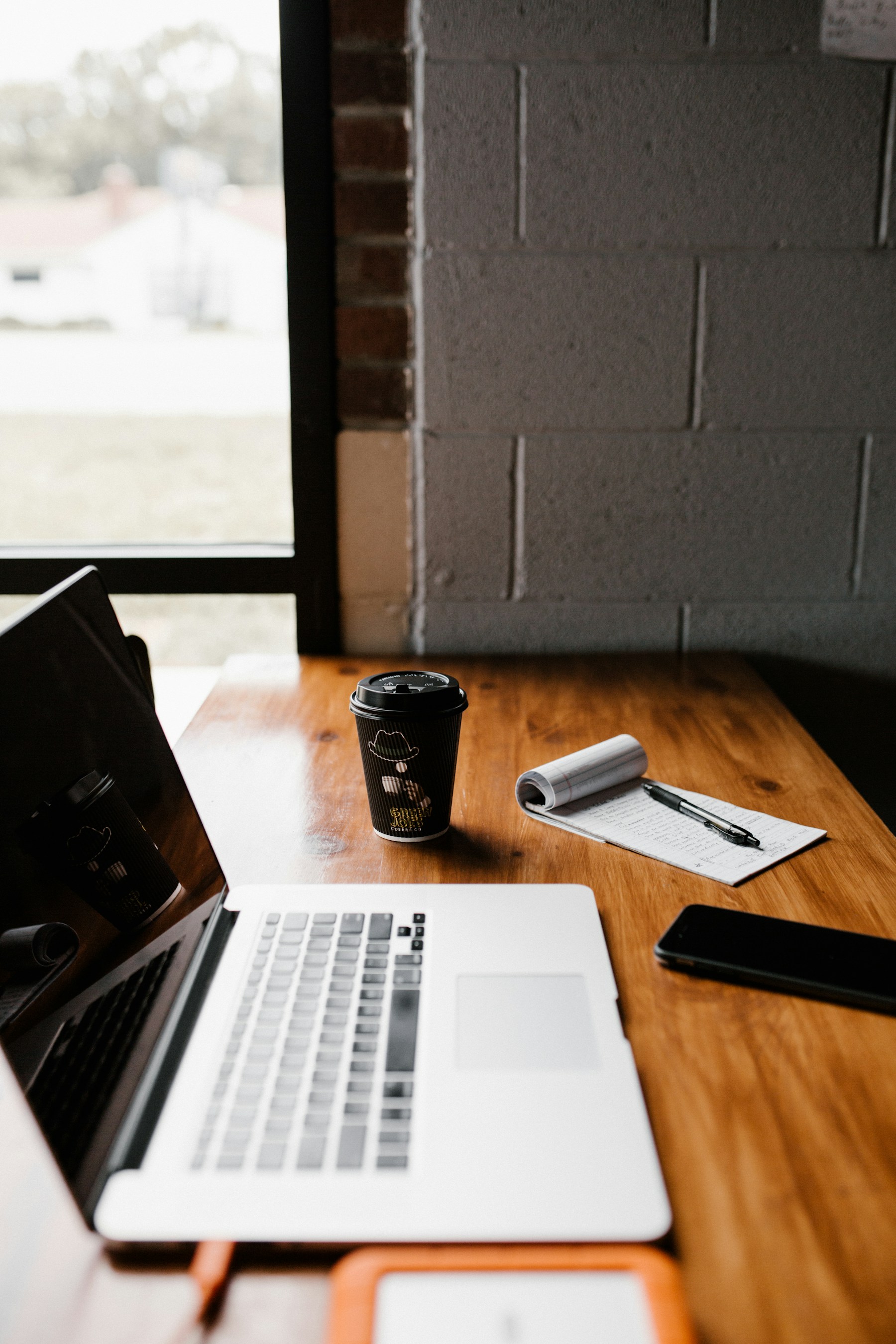 Illustrative real workspace with a laptop, coffee and notebook